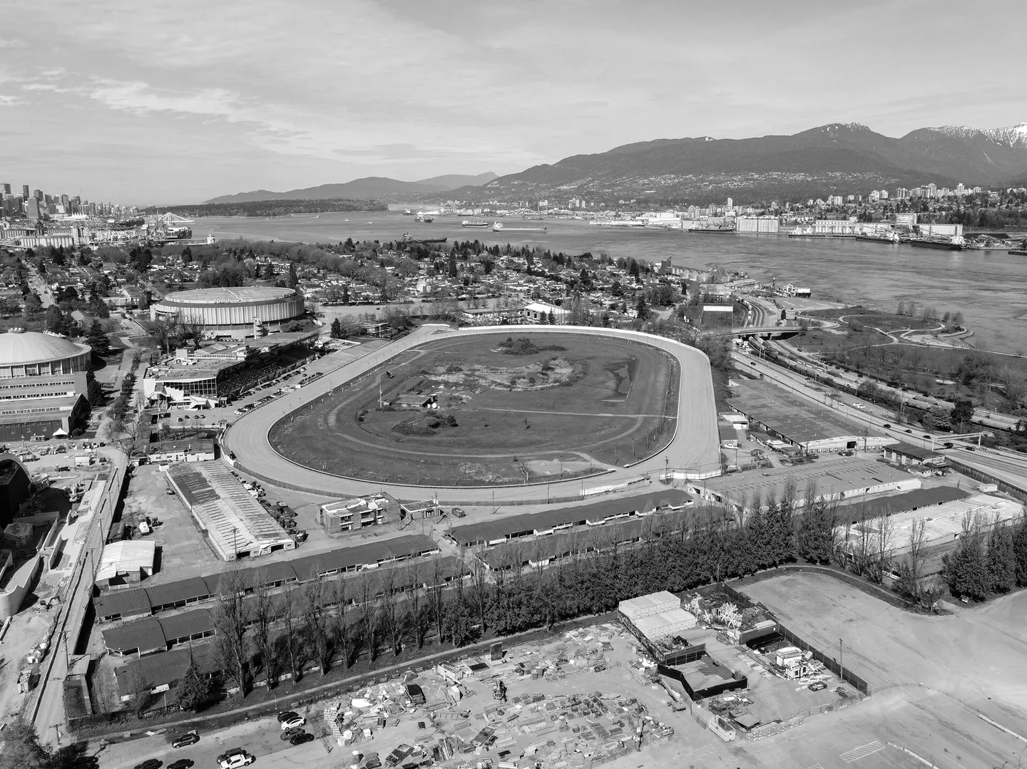 Aerial view of Hastings Racecourse and its grandstand, with Burrard Inlet and the North Shore mountains